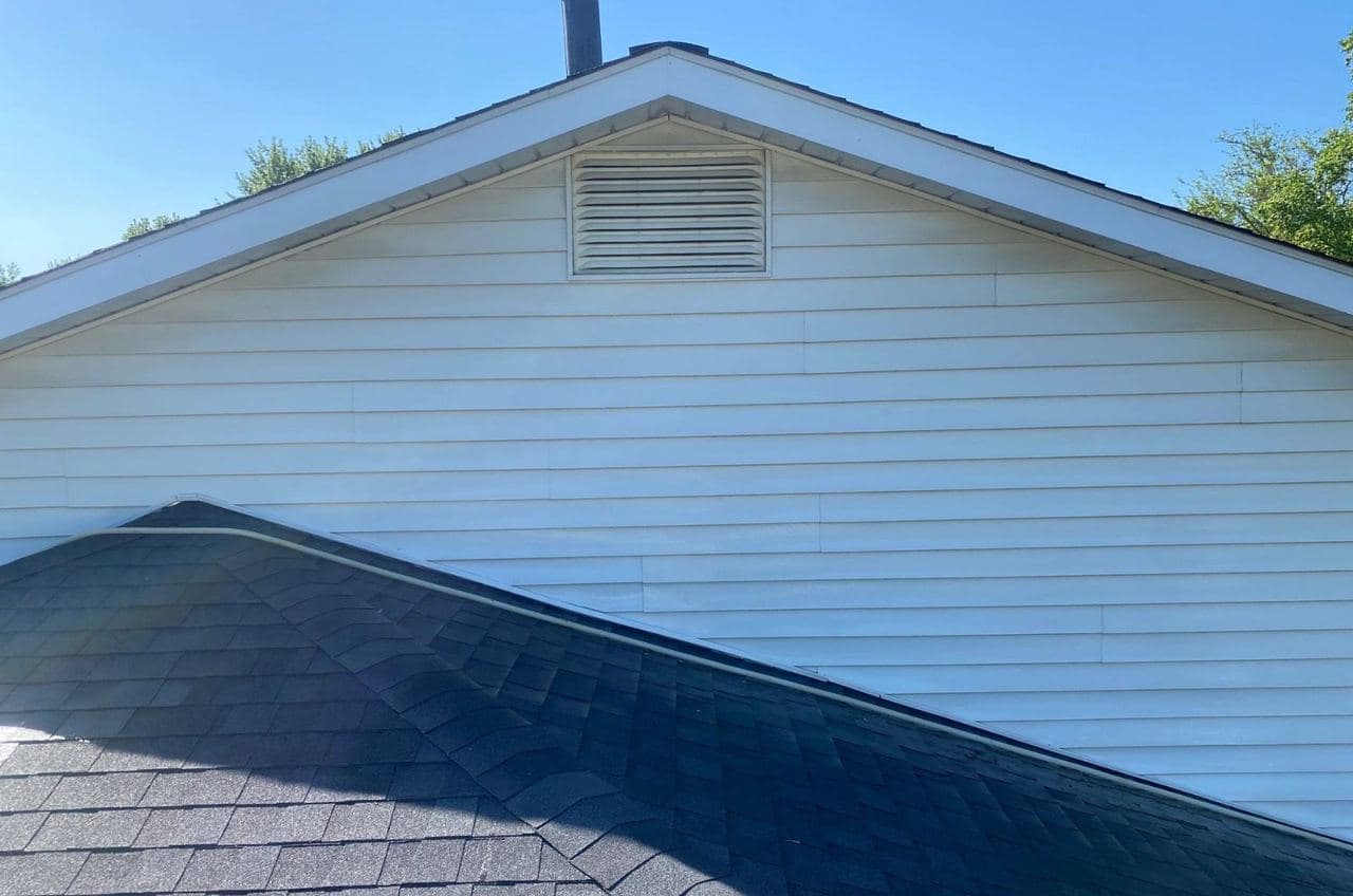 Clean white siding and shingle roof on a home after our softwash